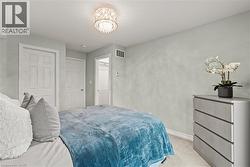 Bedroom featuring light carpet and suspended lighting - 