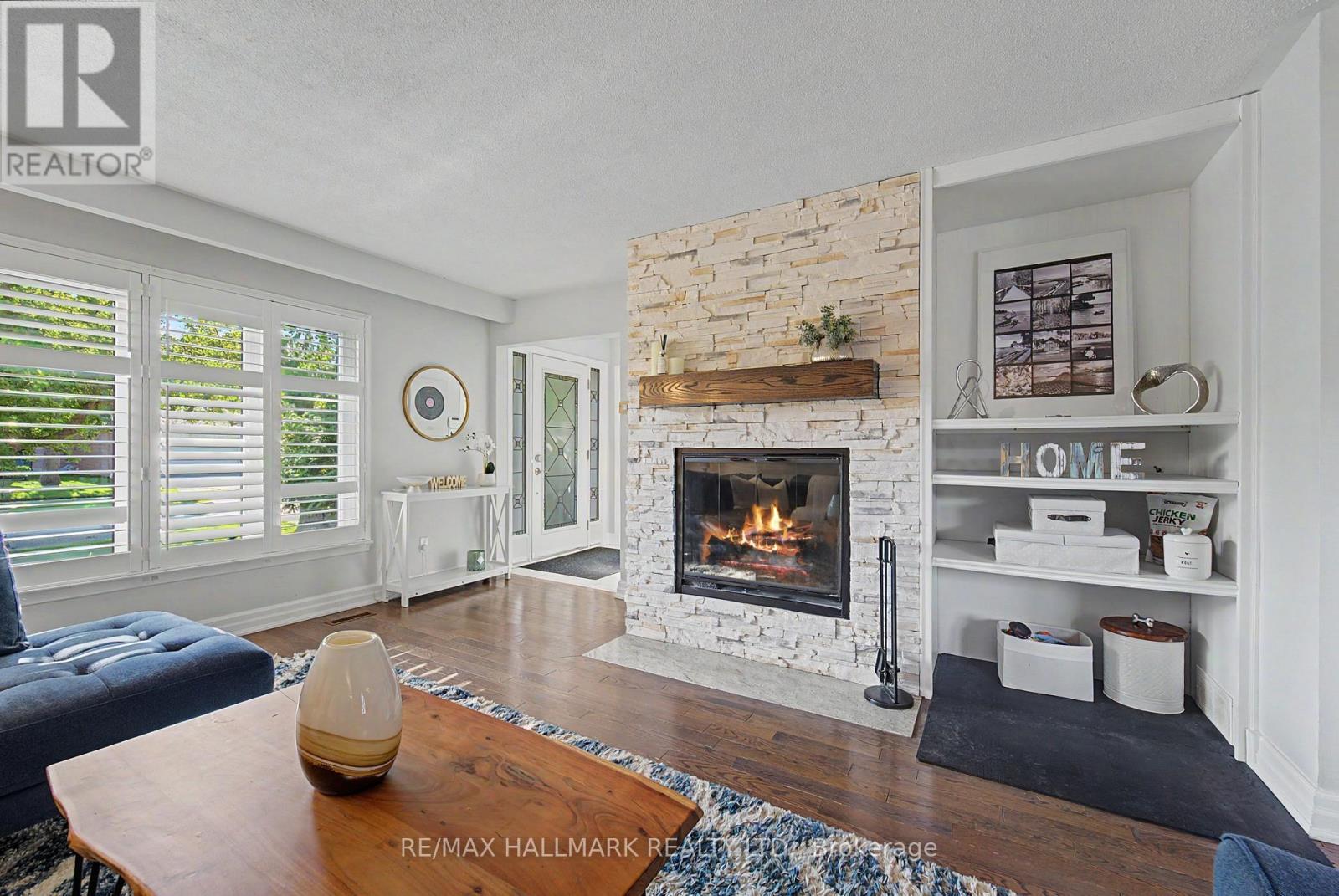 wood burning FP California shutters hardwood - 117 Clappison Boulevard, Toronto, ON - Indoor Photo Showing Living Room With Fireplace