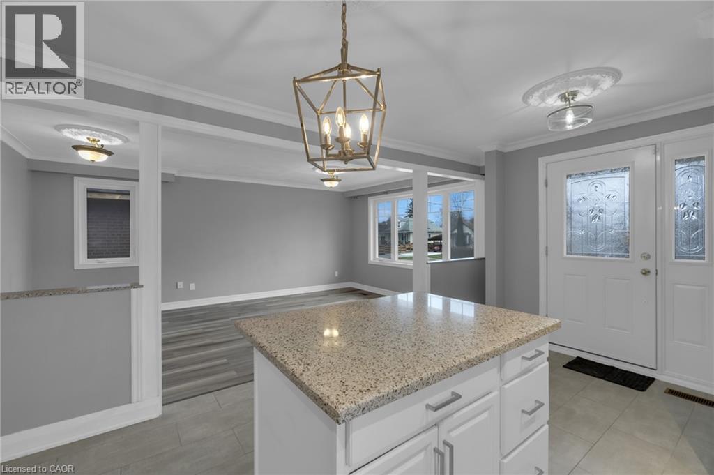 Kitchen island featuring a speckled countertop and white cabinetry with brushed nickel hardware - 197 Troy Street, Mississauga, ON - Indoor