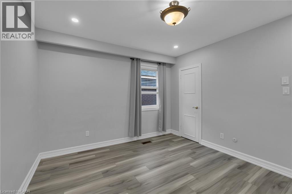 Room featuring wood-finish flooring, recessed lighting, and a window with blinds - 197 Troy Street, Mississauga, ON - Indoor Photo Showing Other Room