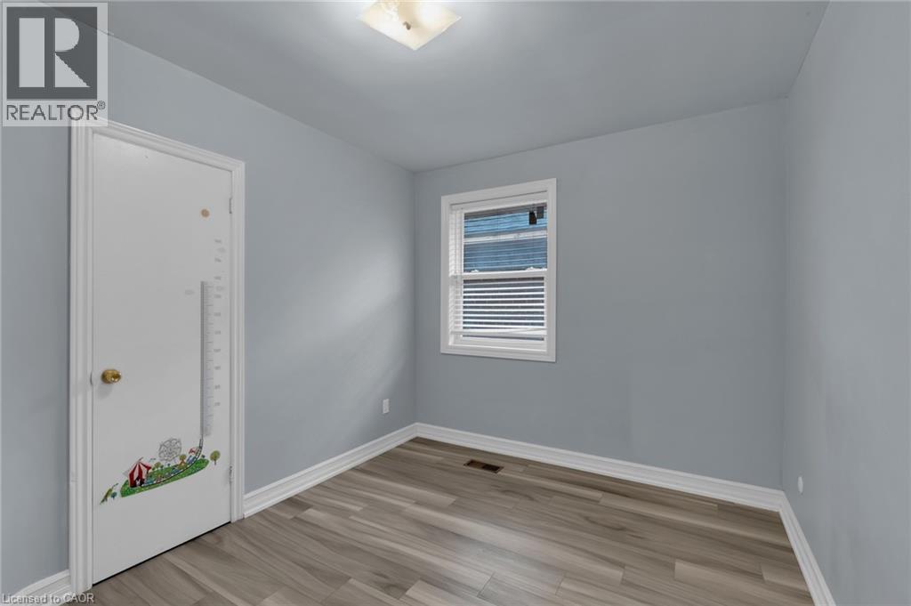 Room with wood-finish flooring, light blue wall paint, and white trim - 197 Troy Street, Mississauga, ON - Indoor Photo Showing Other Room