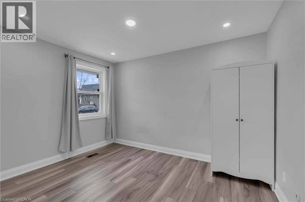 Room featuring light gray walls, wood-finish flooring, white baseboards, and recessed lighting - 197 Troy Street, Mississauga, ON - Indoor Photo Showing Other Room