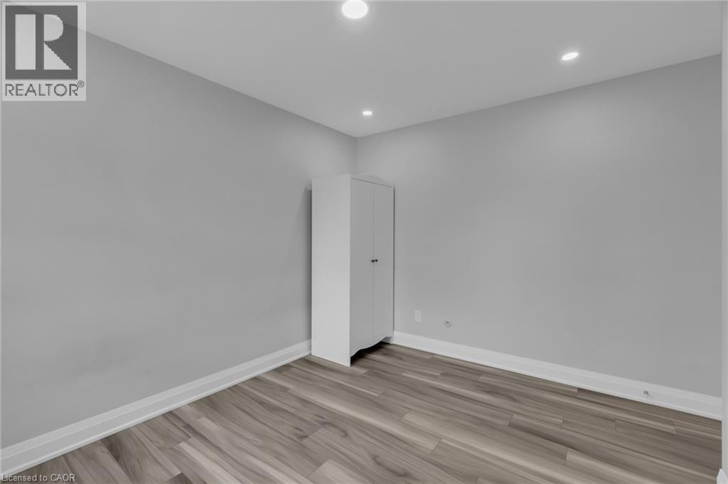 Room featuring light gray walls, recessed lighting, wood-finish flooring, and white baseboards - 197 Troy Street, Mississauga, ON - Indoor Photo Showing Other Room