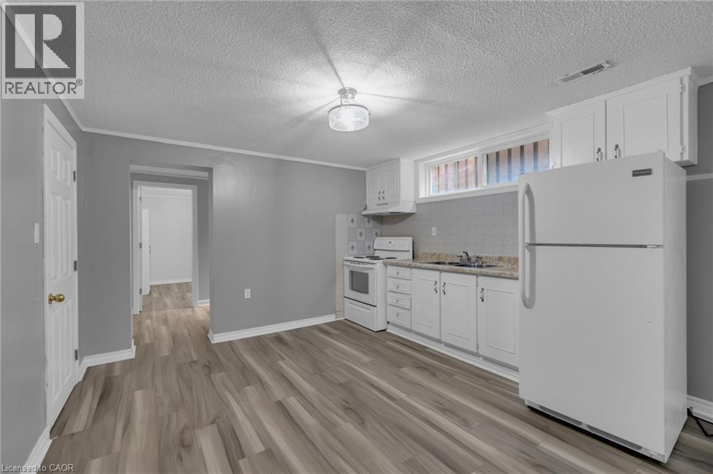 Kitchenette featuring white cabinetry, a white refrigerator, and a white electric range - 197 Troy Street, Mississauga, ON - Indoor Photo Showing Kitchen
