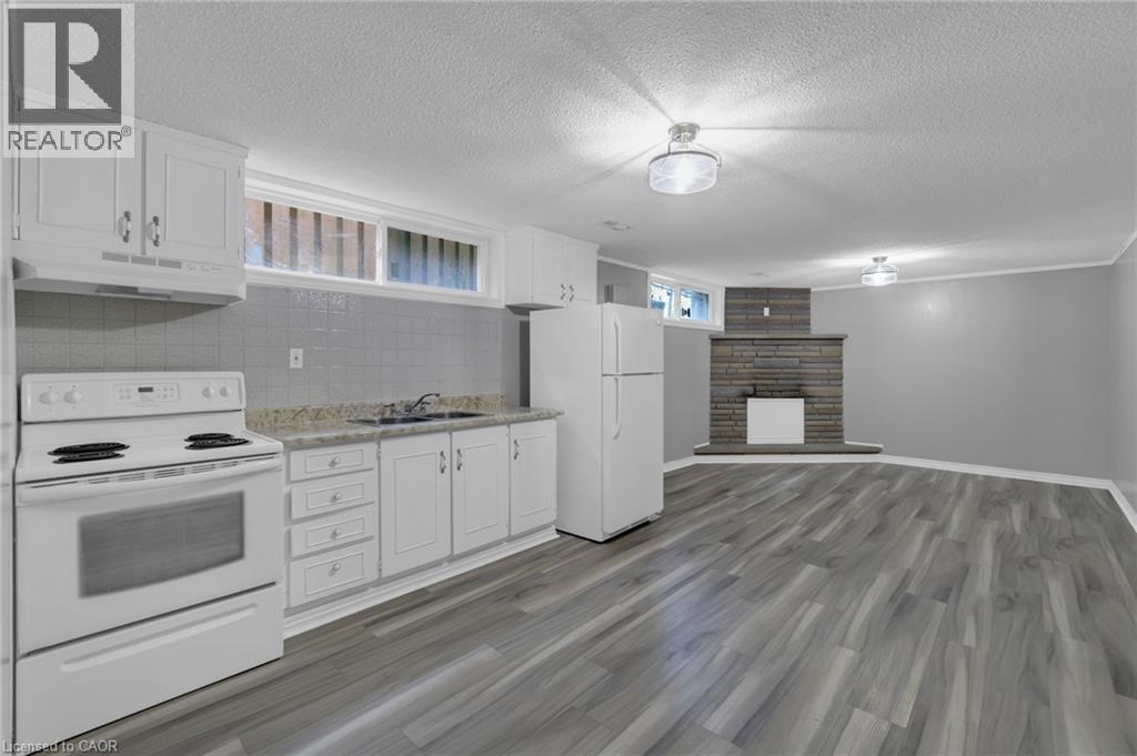 Integrated kitchen area featuring white cabinetry, a white stove, and a white refrigerator - 197 Troy Street, Mississauga, ON - Indoor Photo Showing Kitchen With Double Sink