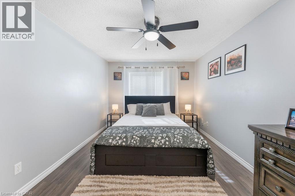 Room featuring wood-finish flooring, a window with horizontal blinds, and a ceiling fan with integrated lighting - 33 Remple Court, Cambridge, ON - Indoor Photo Showing Bedroom