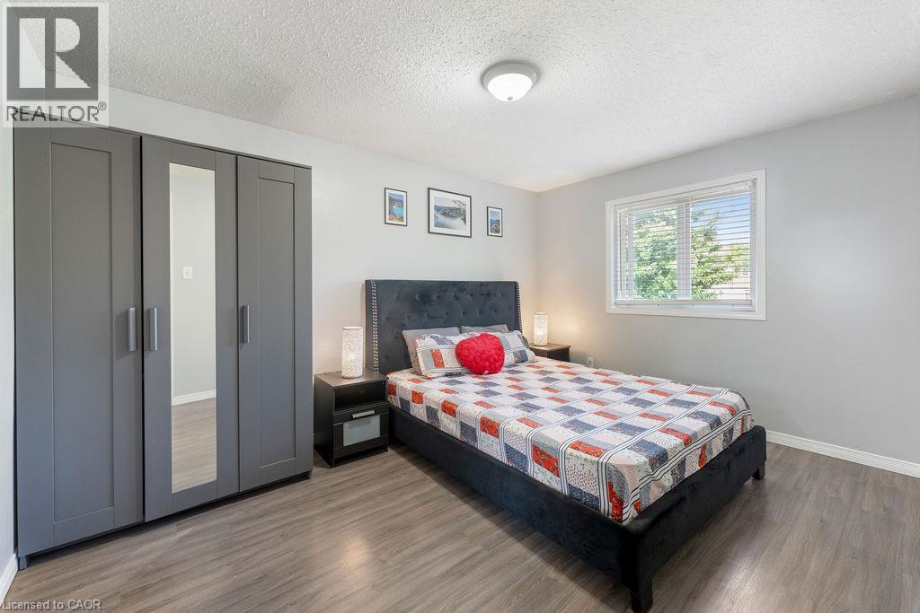 Bedroom featuring wood-finish flooring, light gray walls, and a window with horizontal blinds - 33 Remple Court, Cambridge, ON - Indoor Photo Showing Bedroom