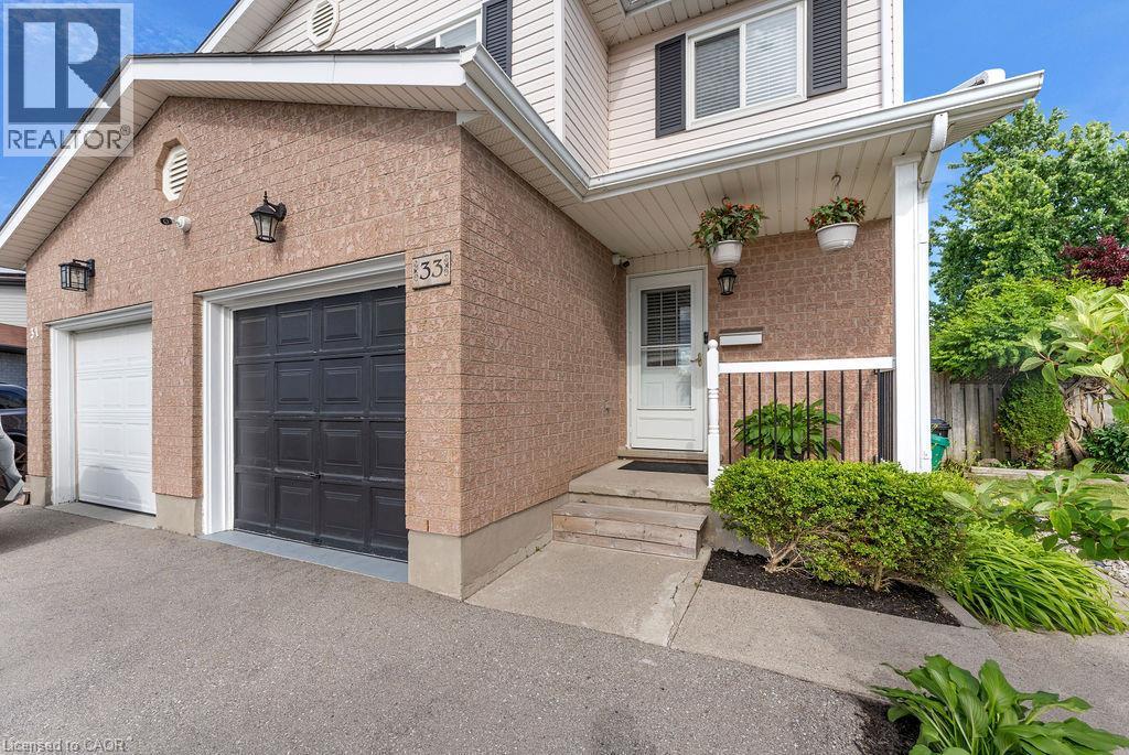 Brick and siding exterior featuring two garage doors, a covered entry, and established landscaping - 33 Remple Court, Cambridge, ON - Outdoor With Exterior