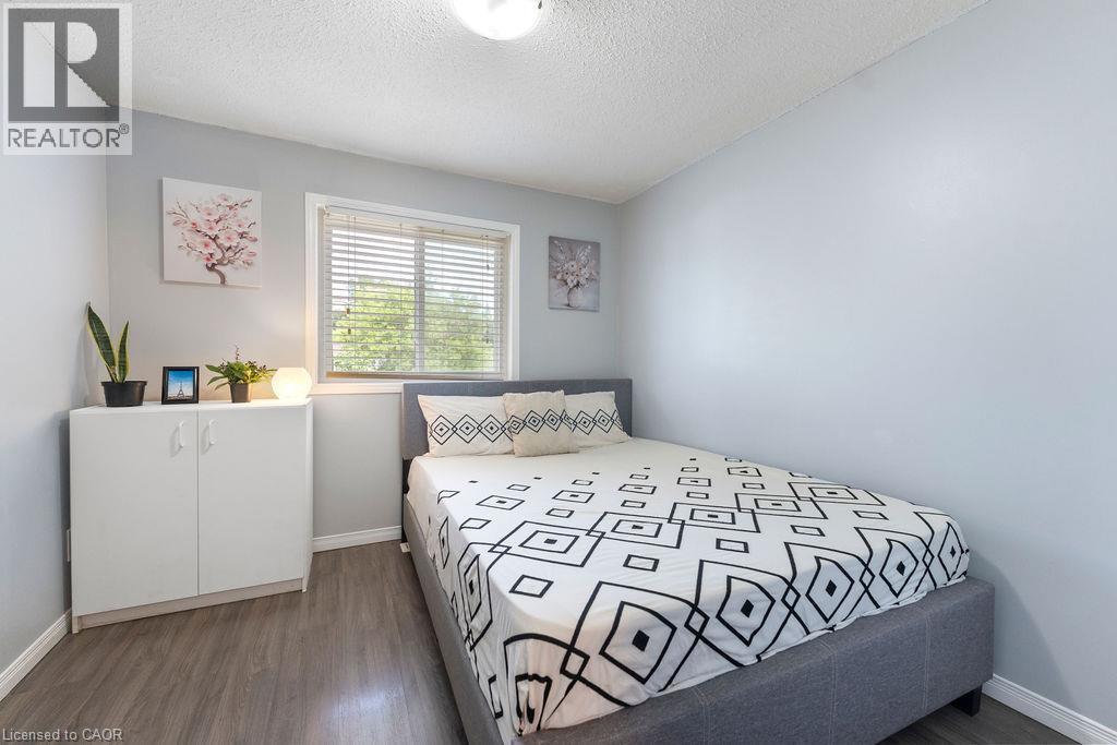 Bedroom featuring wood-finish flooring, a white trim window with blinds, and light-toned walls - 33 Remple Court, Cambridge, ON - Indoor Photo Showing Bedroom