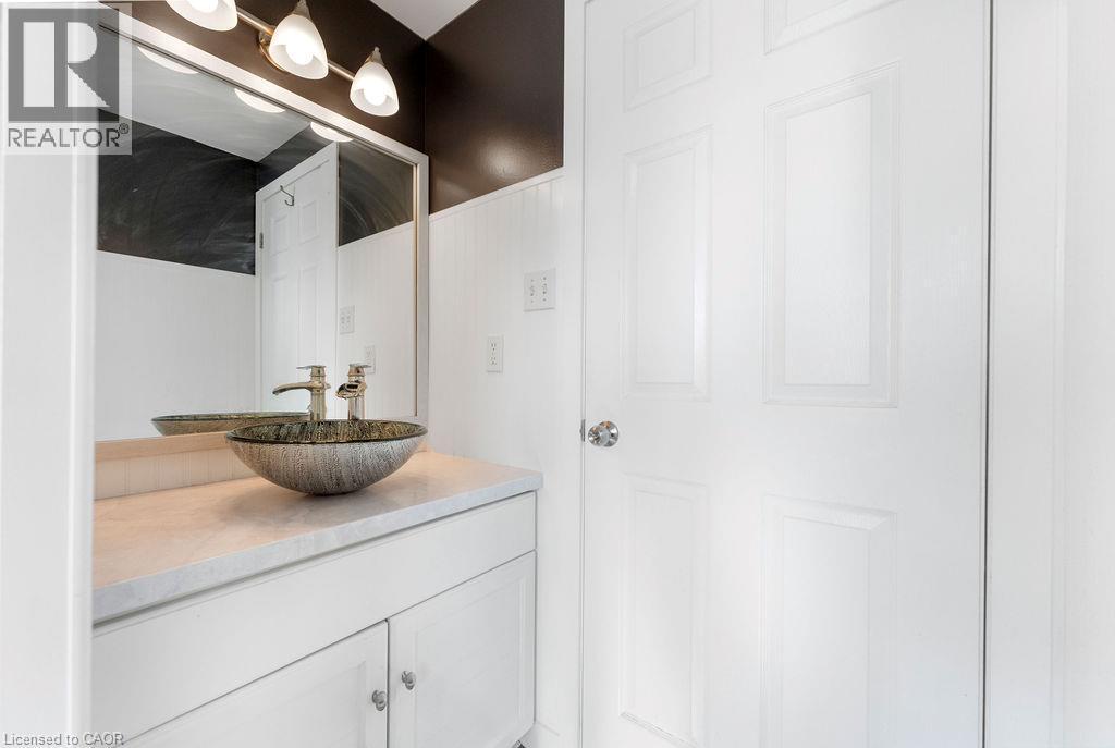 Contemporary vessel sink with brushed nickel faucet, set on a light-toned countertop - 33 Remple Court, Cambridge, ON - Indoor