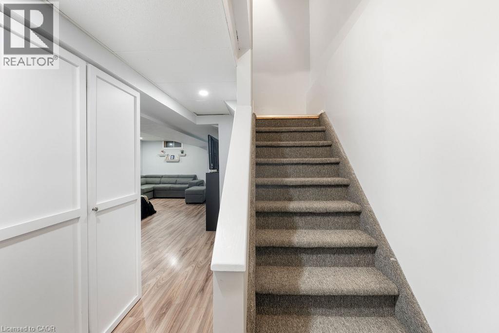 Carpeted staircase with light wood-finish flooring - 33 Remple Court, Cambridge, ON - Indoor Photo Showing Other Room