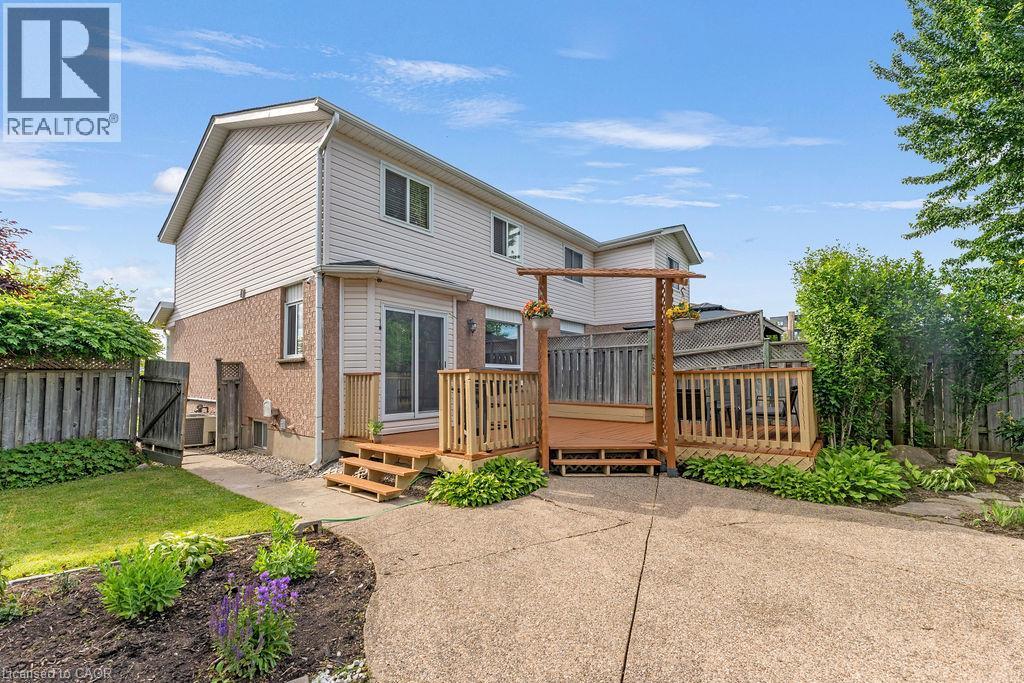 Spacious backyard featuring a multi-level wooden deck with baluster railing, an attached arbor, and a sliding glass door entry to the home - 33 Remple Court, Cambridge, ON - Outdoor With Deck Patio Veranda