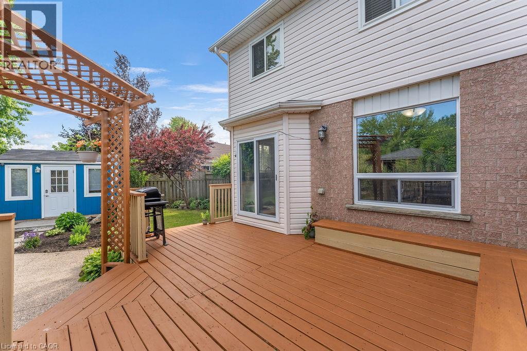 Expansive wood deck with a built-in bench, offering direct access to the backyard through a sliding glass door - 33 Remple Court, Cambridge, ON - Outdoor With Deck Patio Veranda With Exterior