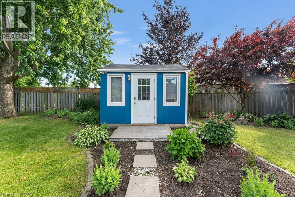Outdoor shed featuring a vibrant blue exterior, white trim, and a white paneled door with glass inserts - 33 Remple Court, Cambridge, ON - Outdoor