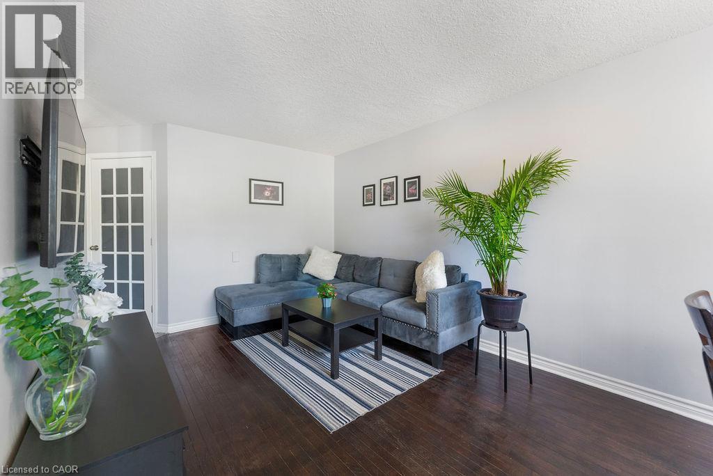 Living area featuring dark wood-finish flooring, light grey painted walls, and white baseboards - 33 Remple Court, Cambridge, ON - Indoor Photo Showing Living Room