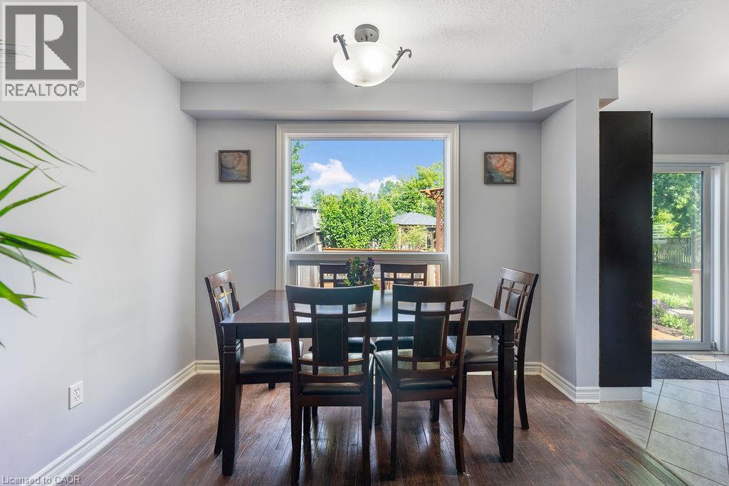 Dining area with wood-finish flooring, a large window, a ceiling-mounted light fixture, and light gray wall paint - 33 Remple Court, Cambridge, ON - Indoor Photo Showing Dining Room