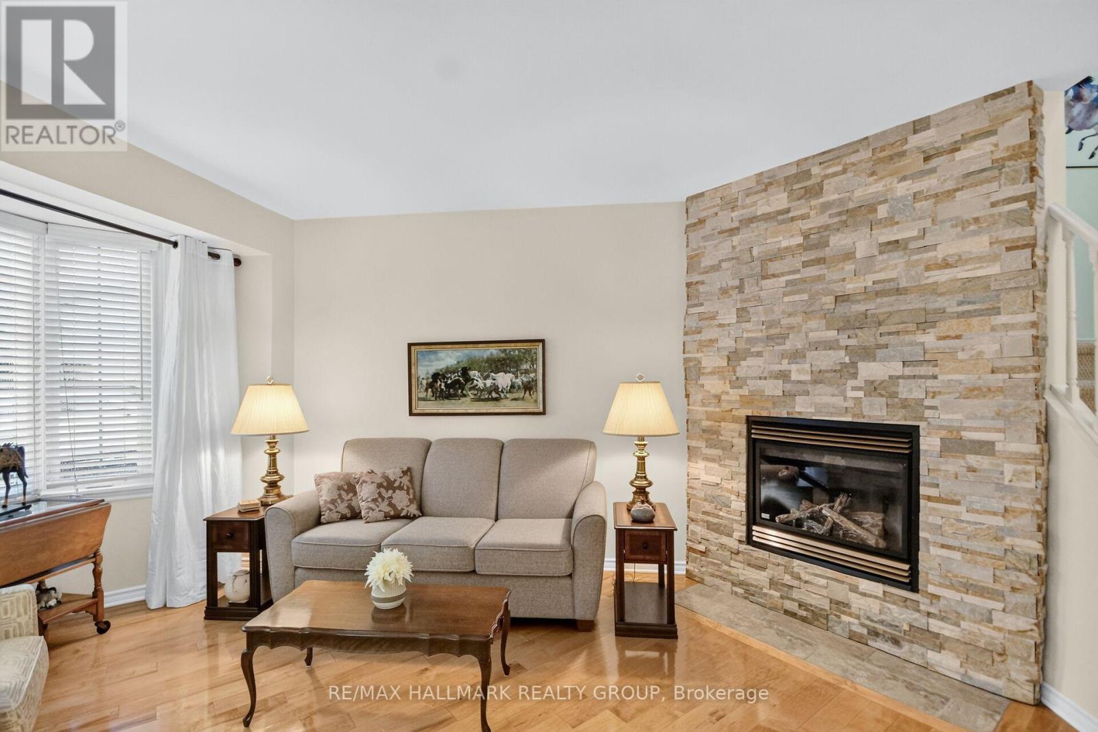 Spacious living room with stone wall gas fireplace - 12 Ready Way, Ottawa, ON - Indoor Photo Showing Living Room With Fireplace