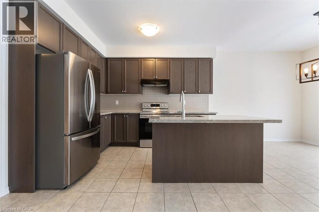 Kitchen featuring stainless steel appliances, backsplash, a sink, dark brown cabinetry, and under cabinet range hood - 13 Steven Drive, Thorold, ON - Indoor Photo Showing Kitchen