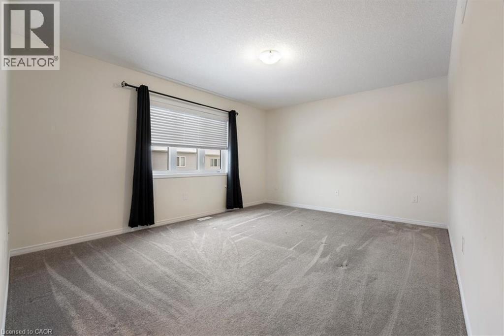 Carpeted spare room featuring a textured ceiling and baseboards - 13 Steven Drive, Thorold, ON - Indoor Photo Showing Other Room