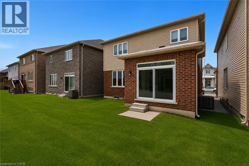 Expansive green lawn with a two-story residence featuring a brick and siding exterior - 13 Steven Drive, Thorold, ON - Outdoor With Exterior