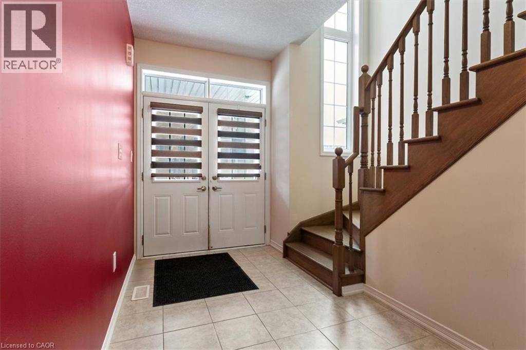 Entrance foyer with light tile patterned floors, stairs, baseboards, and a textured ceiling - 13 Steven Drive, Thorold, ON - Indoor Photo Showing Other Room