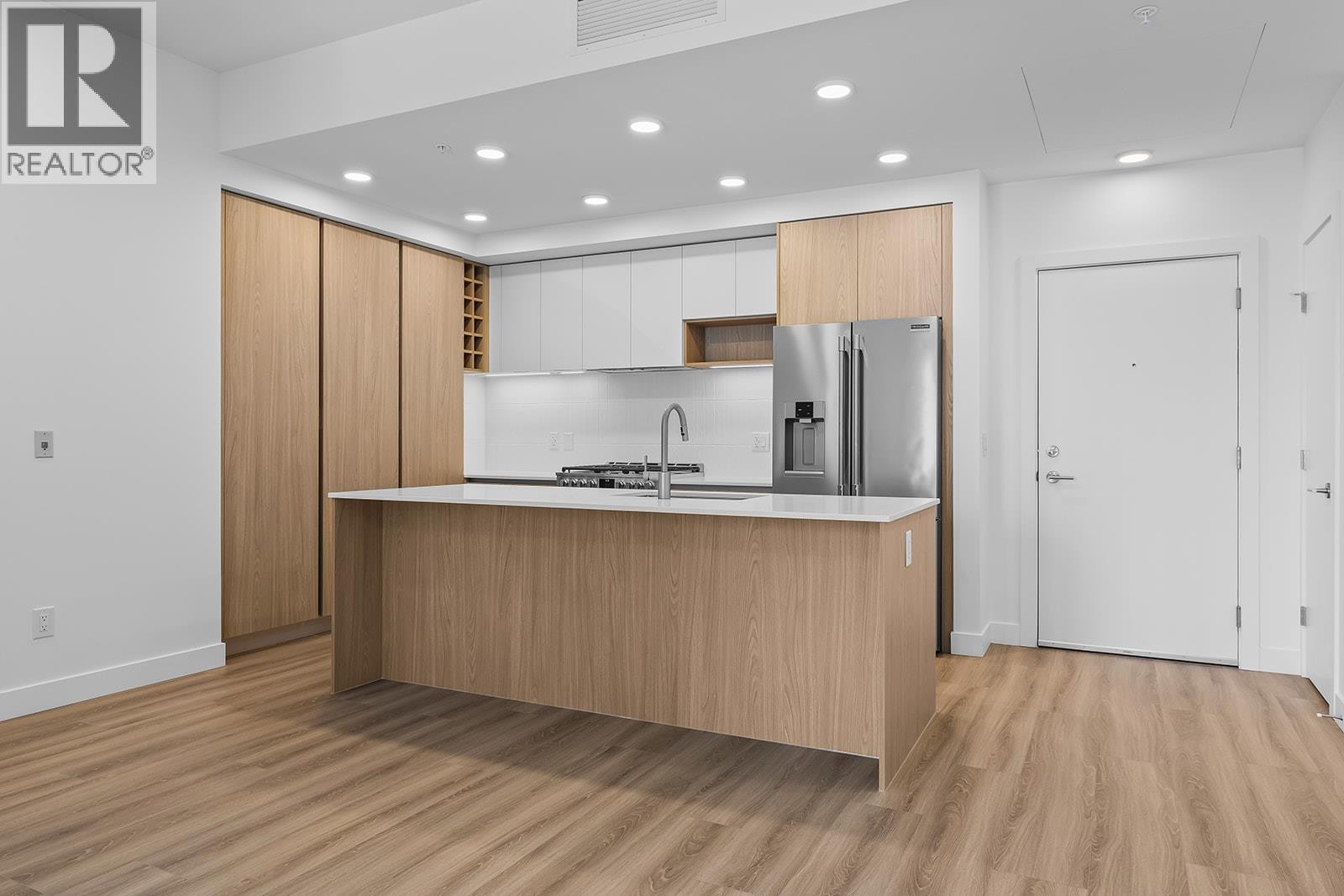 Kitchen complete with gas range, range hood, refrigerator, microwave, dishwasher, plenty of storage space and kitchen island - 2780 Olalla Road Unit# 201, West Kelowna, BC - Indoor Photo Showing Kitchen With Upgraded Kitchen