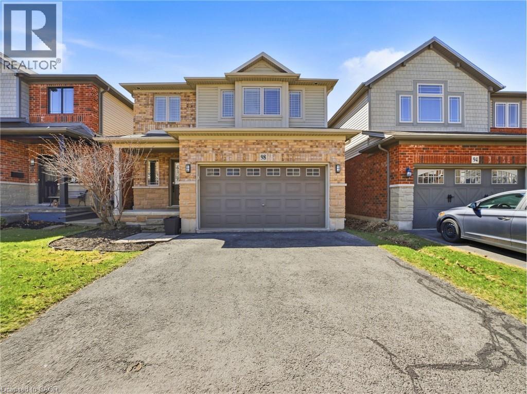 Traditional-style residence featuring a combination of brick and siding exterior, an attached garage, a covered front porch, and a paved driveway - 98 Willow Lane, Grimsby, ON - Outdoor With Facade