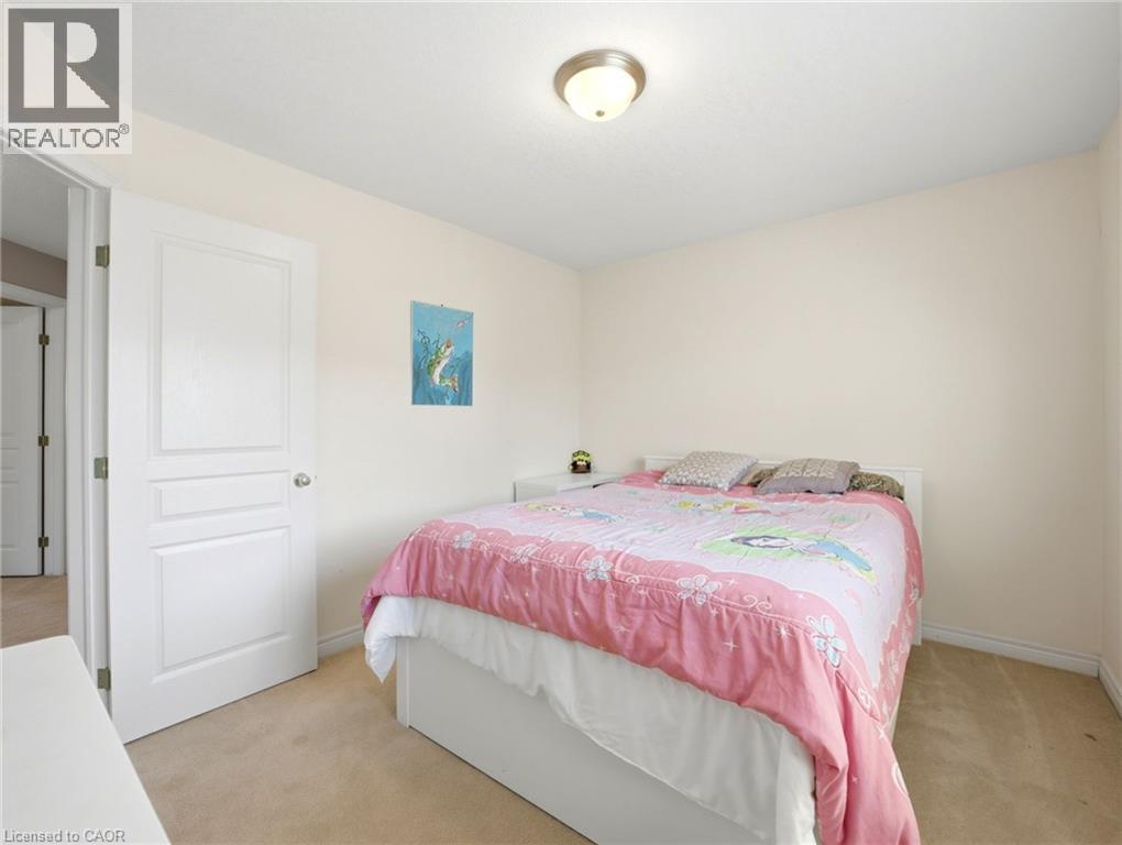 Bedroom featuring light beige wall paint, a white interior door with panel detailing, and a flush mount ceiling light fixture - 98 Willow Lane, Grimsby, ON - Indoor Photo Showing Bedroom