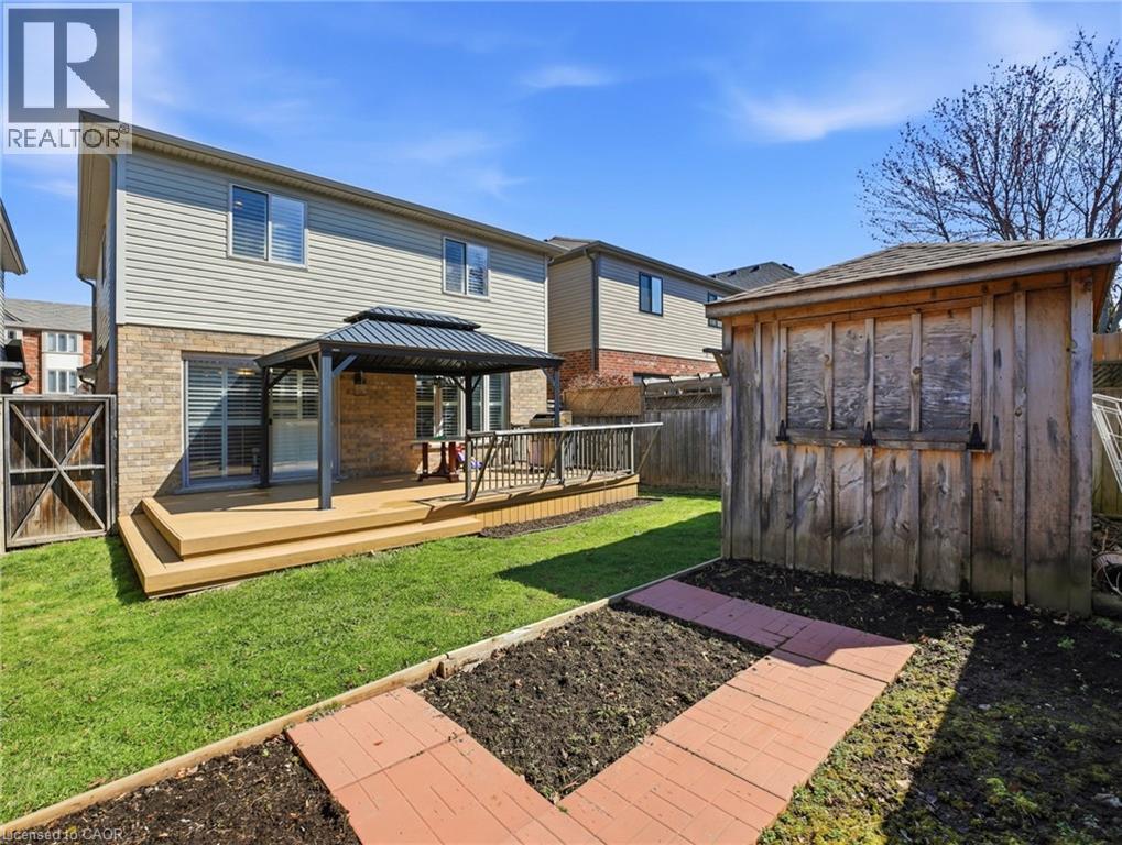 Rear exterior featuring a multi-level wood-finish deck with a metal gazebo, brick facade, and horizontal siding - 98 Willow Lane, Grimsby, ON - Outdoor With Deck Patio Veranda