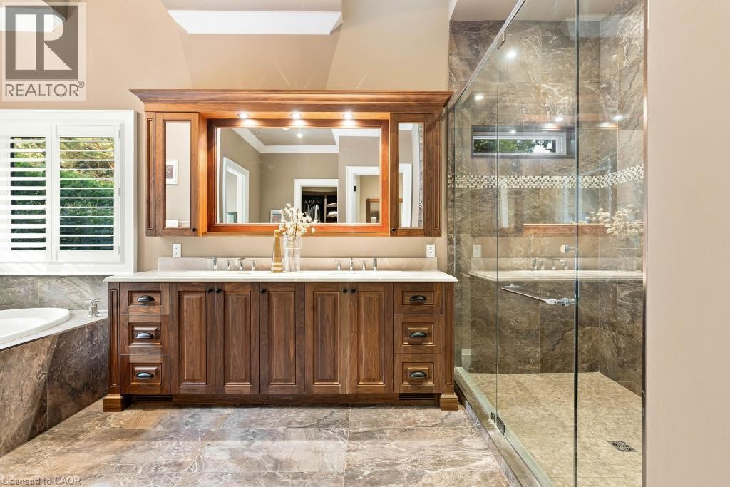 Dual vanity with wood-finish cabinetry, integrated mirrors, and sconce lighting - 253 Rossmore Boulevard, Burlington, ON - Indoor Photo Showing Bathroom
