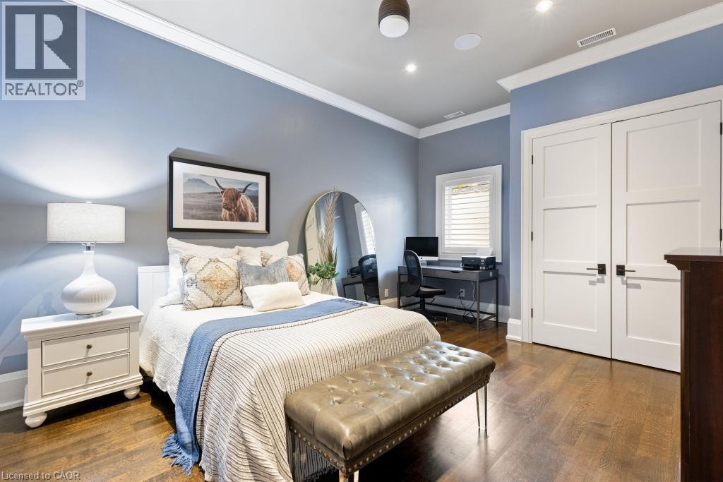 Hardwood flooring, recessed lighting, white crown molding, white doors with dark hardware, and a window with white blinds - 253 Rossmore Boulevard, Burlington, ON - Indoor Photo Showing Bedroom
