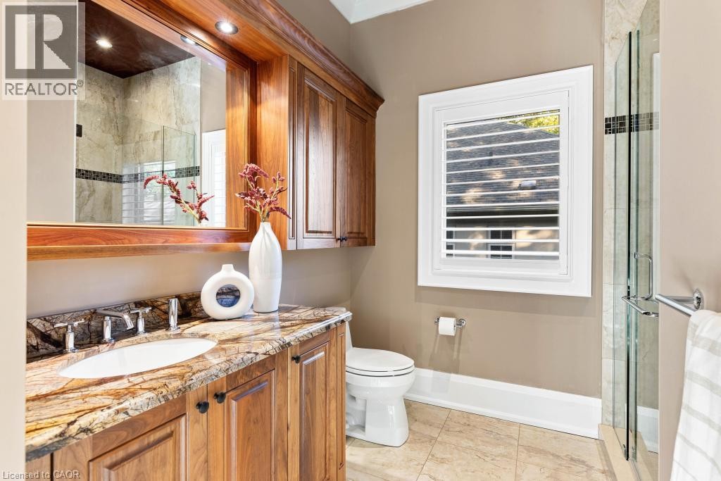 Warm wood vanity with an integrated sink and natural stone countertop - 253 Rossmore Boulevard, Burlington, ON - Indoor Photo Showing Bathroom