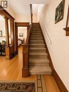 Original hardwood floors, a beautiful wood staircase with classic balusters, and a wood-trimmed entry into the dining room add warmth and timeless character. - 