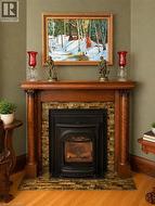 A charming fireplace with a rich wood mantle, decorative tile surround, and black insert adds warmth and character to the room. - 