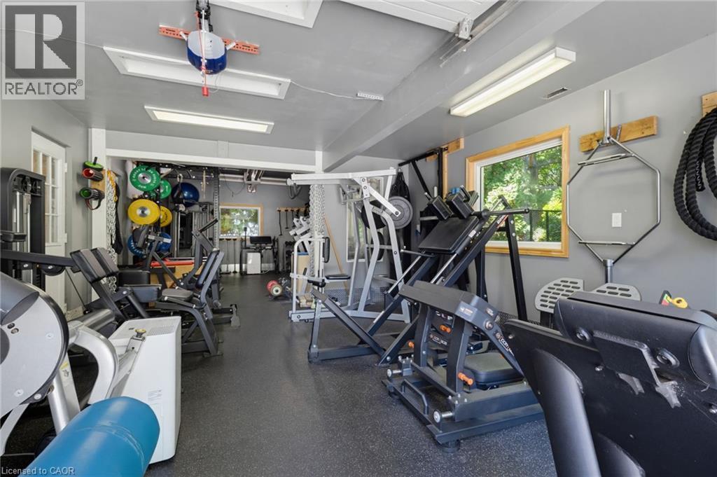Dedicated home gym featuring comprehensive fitness equipment, including cardio machines, strength training apparatus, and weight storage - 21 Kerman Avenue, Grimsby, ON