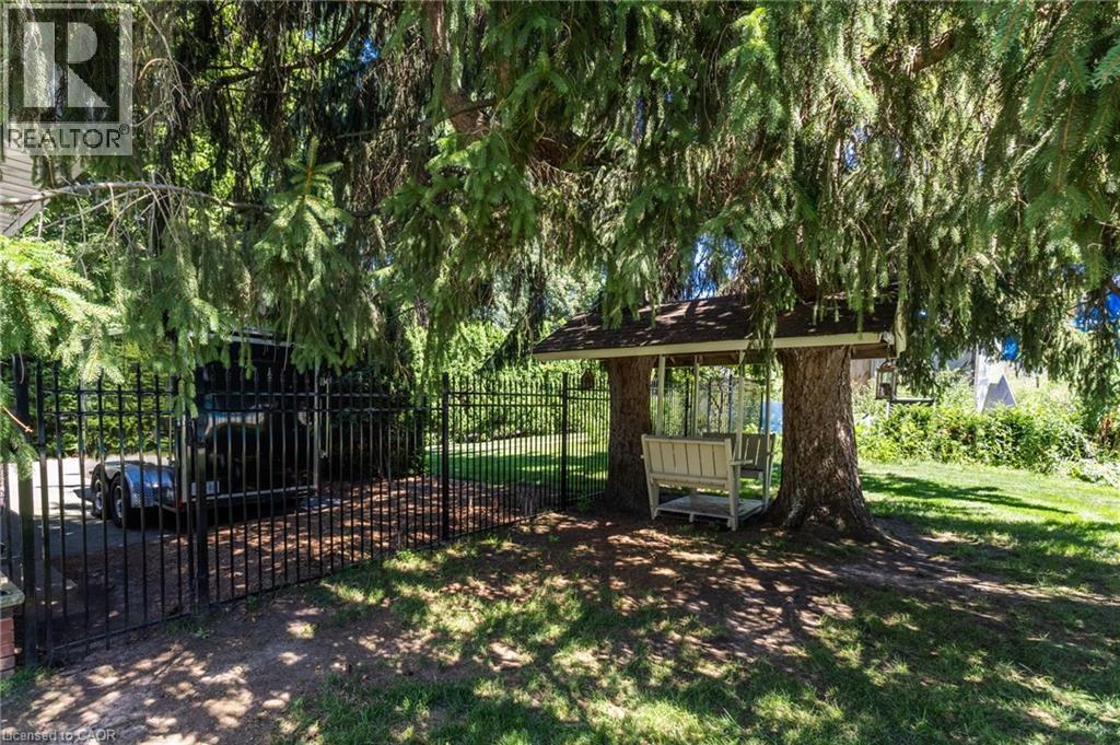 Mature landscaping with towering trees provides natural shade throughout the grounds - 21 Kerman Avenue, Grimsby, ON