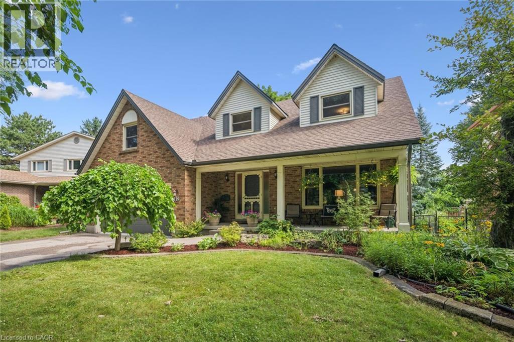 Brick exterior with gabled dormers, covered front porch, and a paved driveway - 119 Sandy Ridge Place, Waterloo, ON - Outdoor With Deck Patio Veranda