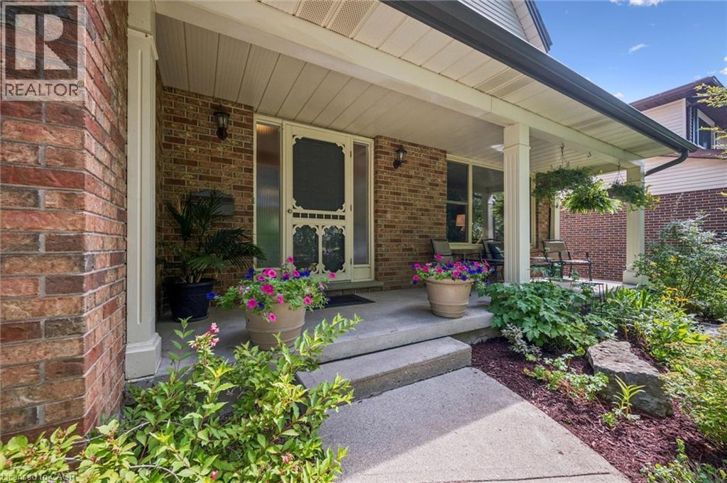 Brick exterior featuring a covered porch, concrete steps, and a decorative screen door - 119 Sandy Ridge Place, Waterloo, ON - Outdoor With Deck Patio Veranda