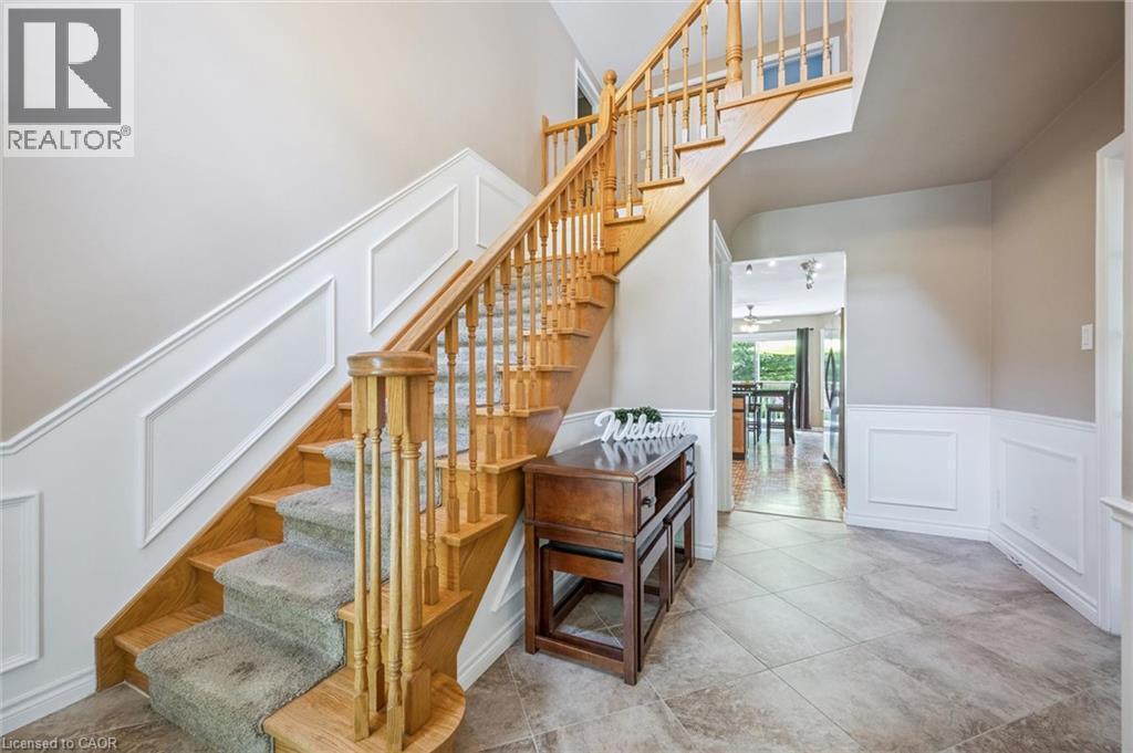 Entryway featuring tile flooring, wainscoting, and a wood staircase with carpeted treads - 119 Sandy Ridge Place, Waterloo, ON - Indoor Photo Showing Other Room
