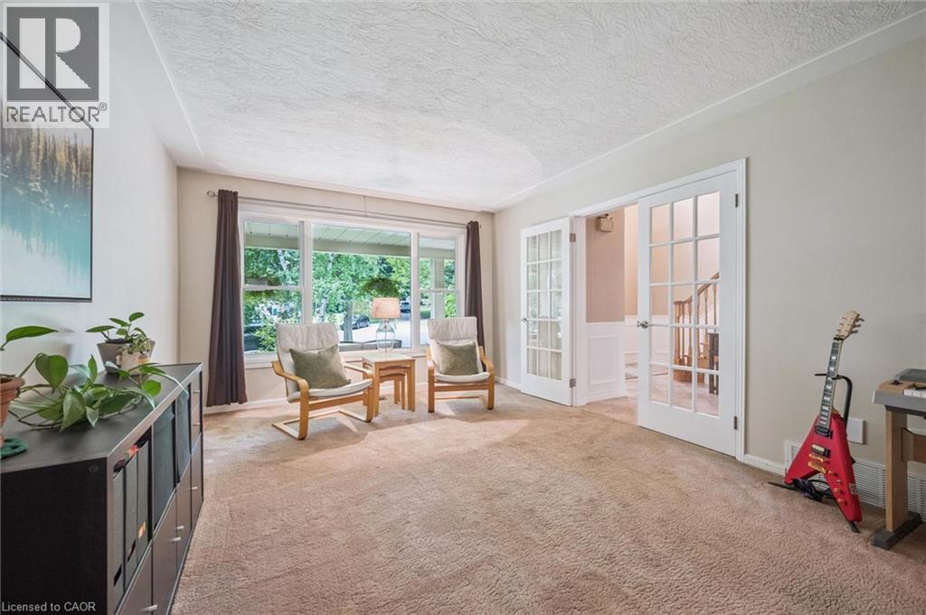 Expansive windows, textured ceiling, double French doors with grid-pane glass, and carpet flooring - 119 Sandy Ridge Place, Waterloo, ON - Indoor