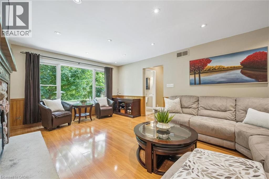 Hardwood flooring, recessed lighting, and a stone-clad fireplace - 119 Sandy Ridge Place, Waterloo, ON - Indoor Photo Showing Living Room