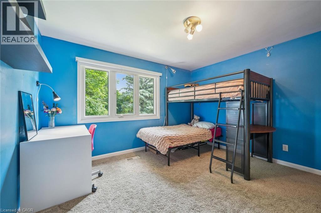 Wall-mounted shelving with a white desk, large window with white trim, track lighting fixture, and carpeted flooring - 119 Sandy Ridge Place, Waterloo, ON - Indoor Photo Showing Bedroom