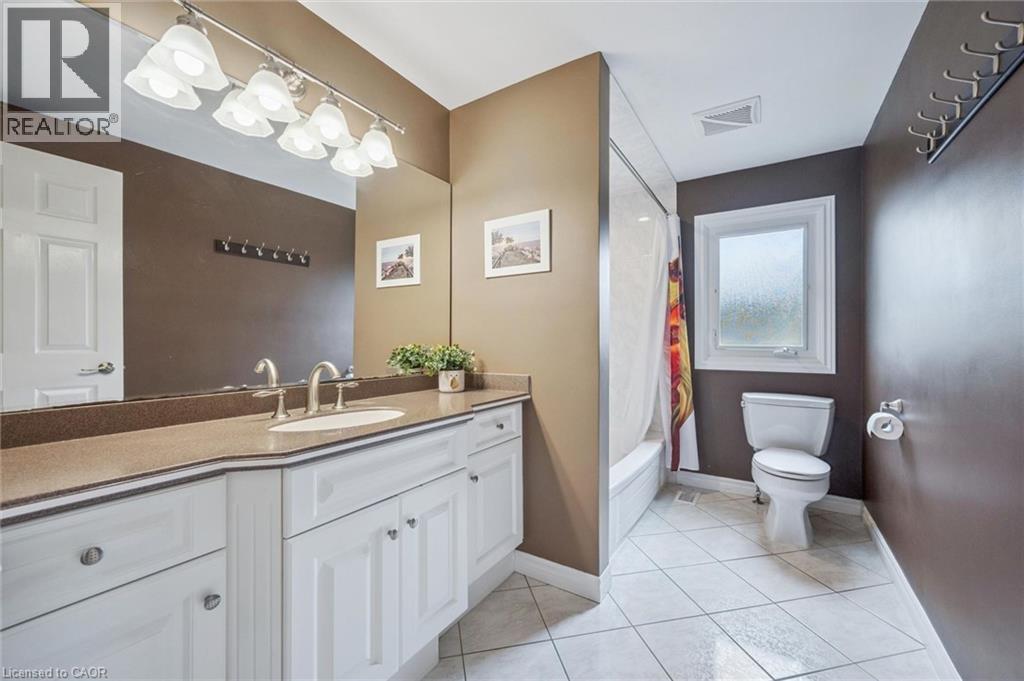 White shaker-style vanity with an integrated sink, brushed nickel faucet, and a large wall-mounted mirror - 119 Sandy Ridge Place, Waterloo, ON - Indoor Photo Showing Bathroom