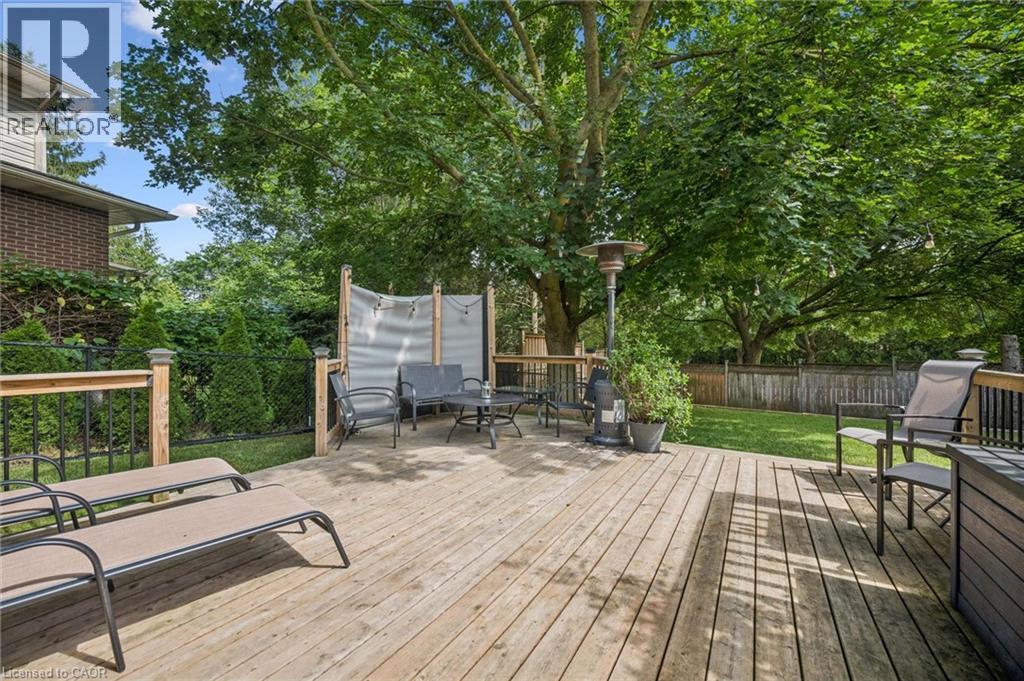 Expansive wood deck with a privacy screen, metal railing, and surrounding mature trees - 119 Sandy Ridge Place, Waterloo, ON - Outdoor With Deck Patio Veranda