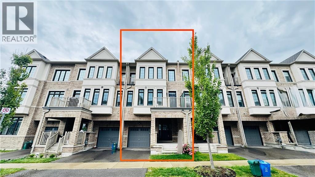 Three-story townhome with a light brick facade, integrated single-car garage, covered entry, and upper-level balcony - 1159 Lloyd Landing, Milton, ON - Outdoor With Facade