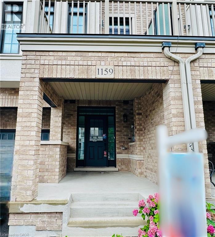 Brick facade with a dark-paneled entry door, concrete steps, and an upper-level balcony with white railings - 1159 Lloyd Landing, Milton, ON - Outdoor