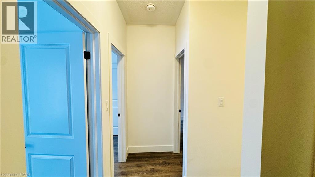 Hallway featuring wood-finish flooring, light-toned walls, recessed lighting, and panel doors - 1159 Lloyd Landing, Milton, ON - Indoor Photo Showing Other Room