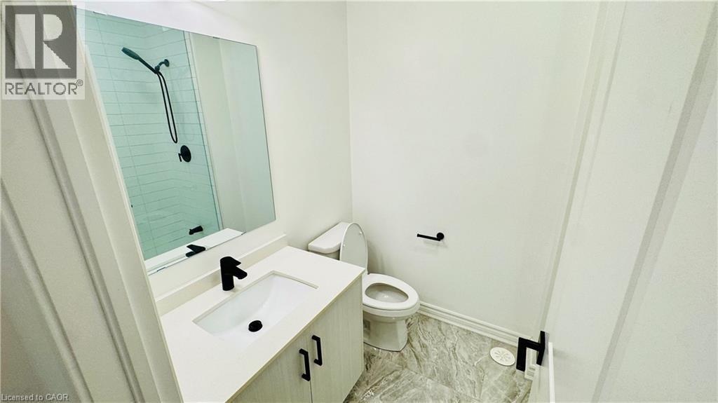 Bathroom featuring a vanity with an integrated sink, matte black faucet, and a large wall mirror - 1159 Lloyd Landing, Milton, ON - Indoor Photo Showing Bathroom