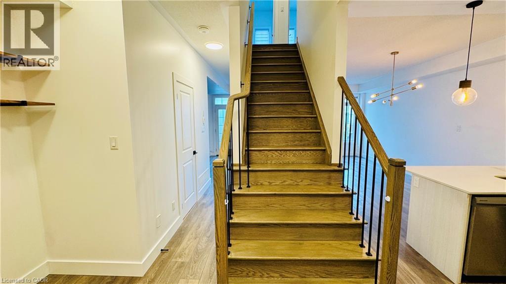 Hardwood staircase with wrought iron balusters - 1159 Lloyd Landing, Milton, ON - Indoor Photo Showing Other Room