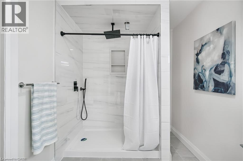 Shower with white subway tile surround, matte black fixtures, and a recessed niche - 10 Comet Avenue Unit# #1 (Main), Hamilton, ON - Indoor Photo Showing Bathroom